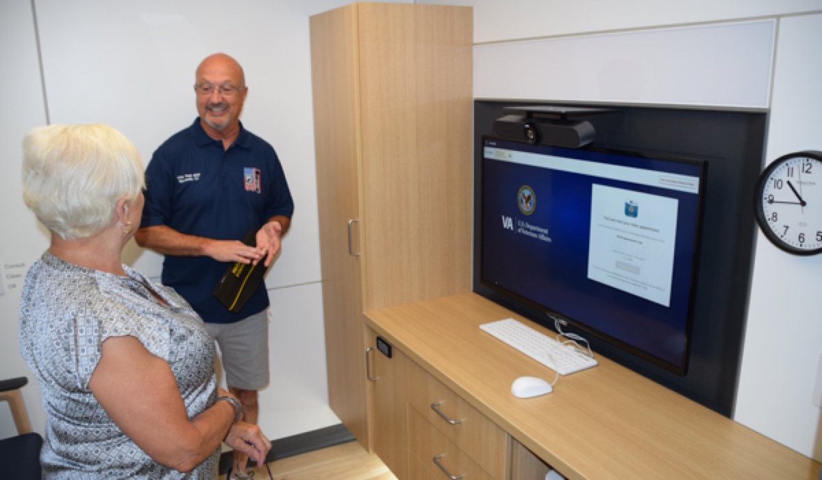ATLAS attendance greeting veteran in an office with telehealth equipments