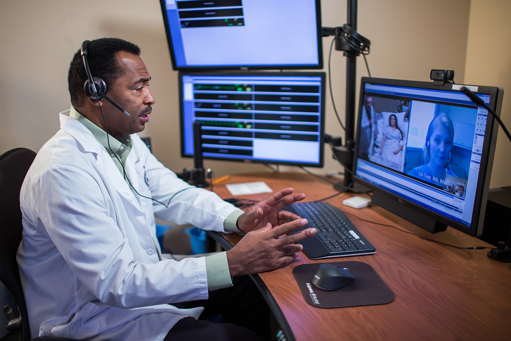Provider on video call remotely with patient and clinician.